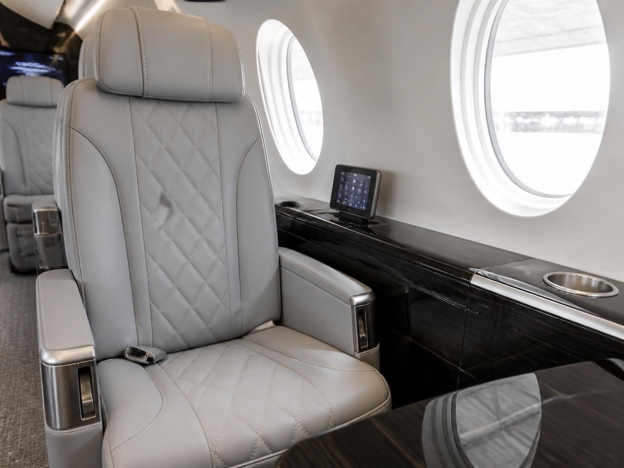 Close-up of conditioned light grey quilted leather seating and brushed aluminum trim